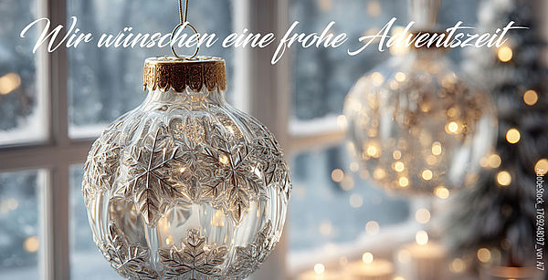 Im Hintergrund sieht man Fenster und Natur im Vordergrund eine Weihnachtskugel mit Ornamenten im Hintergrund rechts sehr verschwommen ebenfalls eine Weihnachtskugel mit Ornamenten